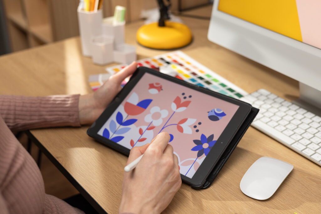 Una mujer crea un diseño floral digital en una tableta